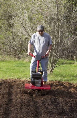 Man Gardening With Rototiller