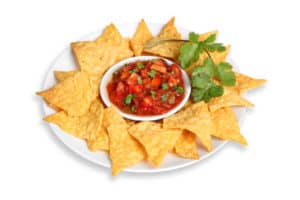Platter of tortilla chips and salsa cut out on white background