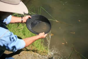 gold panning, man striking it rich by finding the mother lode or